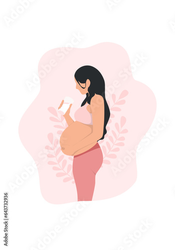 Pregnant woman drinking a glass of milk while holding her abdomen