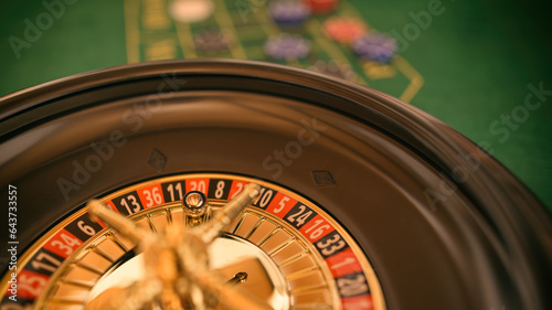 Glücksspiel Roulette mit Rouletterad im Casino an Roulettetisch mit Kugel auf einer roten Zahl