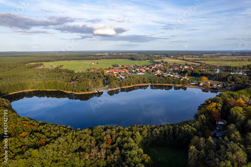 Aerial shot of beautiful lake surrounded by forest in a calm autumn day. Germany. 4K video. © Igor Syrbu