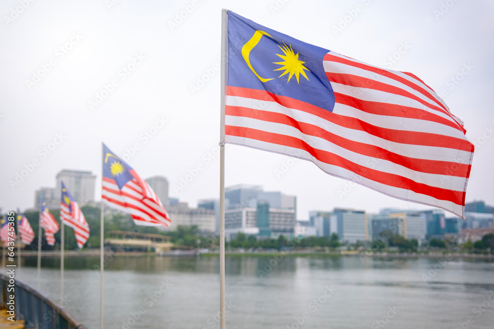 The Malaysia flag is also known as Jalur Gemilang waving with a city in the background. Independence Day or Merdeka Day celebration on 31 August and Hari Malaysia on 16 September, copy space concept.