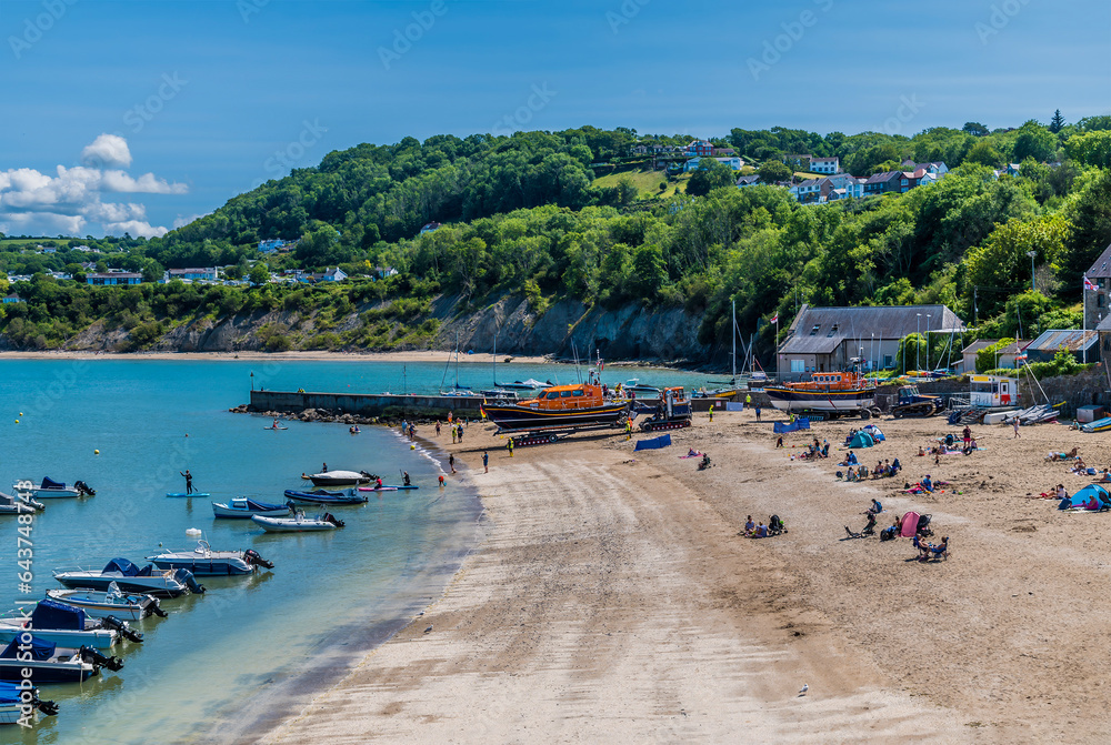 A view along the beach as the tide comes in at New Quay, Wales in summertime