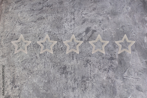 Gold, gray, silver five star shape on the gray concrete background. The best excellent business services rating customer experience concept. Concept image of setting a five star goal. 