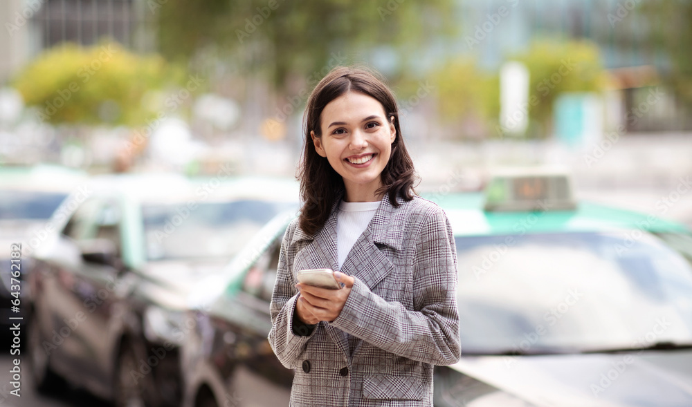 Happy entrepreneur woman using smart phone standing in urban area Happy entrepreneur woman using smart phone standing in urban area