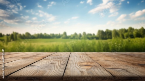 Empty wooden desk with blurred field and clouds background. Copy space. Space for text