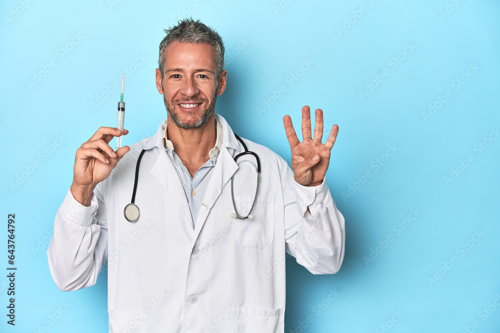 Doctor with a syringe on a blue studio background Doctor with a syringe on a blue studio background