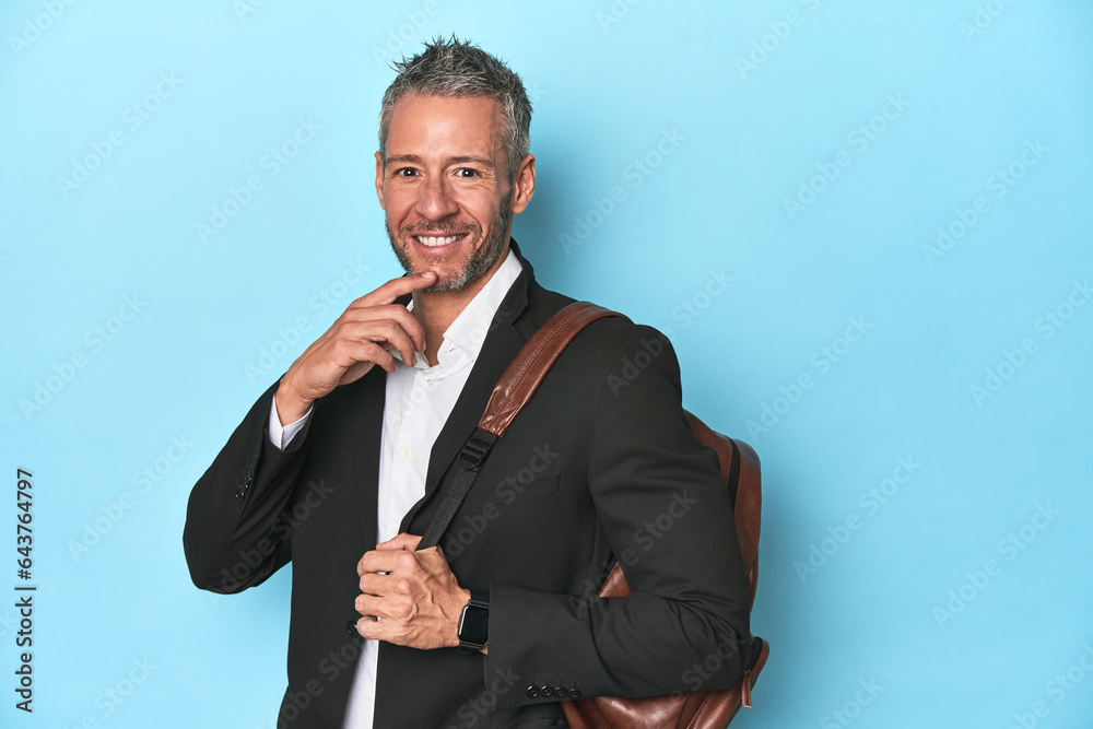 Businessman with a backpack on blue studio backdrop Businessman with a backpack on blue studio backdrop