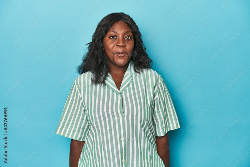 Fototapeta premium Young african american curvy woman shrugs shoulders and open eyes confused.