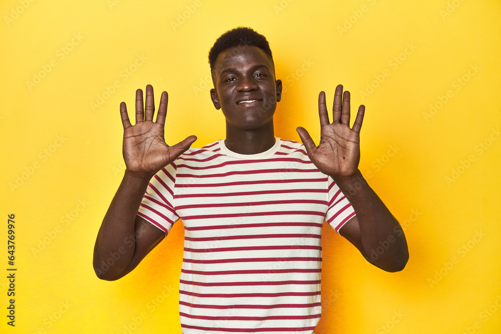 Stylish young African man on vibrant yellow studio background, receiving a pleasant surprise, excited and raising hands. Stylish young African man on vibrant yellow studio background, receiving a pleasant surprise, excited and raising hands.