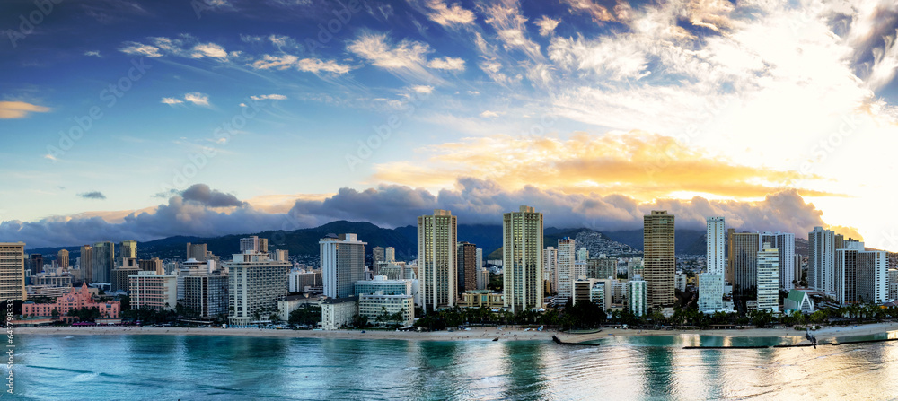 Panorama of world famous Waikiki and its famous beach front at sunrise with clouds over the Koolau Mountains