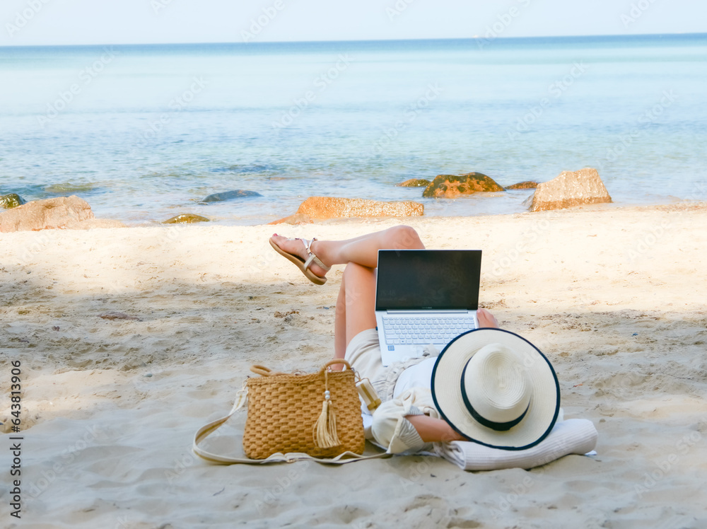 young woman uses laptop computer on the beach. distance work, freelancer and blogger concept. WiFi unlimited