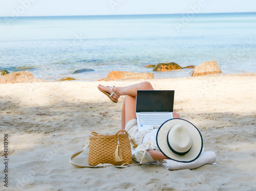 Obraz na płótnie young woman uses laptop computer on the beach. distance work, freelancer and blogger concept. WiFi unlimited w salonie