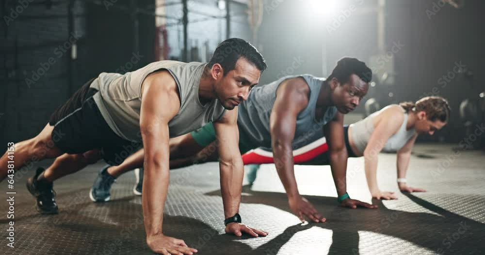 Gym, men and women in floor exercise for strong body, muscle development and balance power. Commitment, motivation and fitness team with personal trainer, training with focus and workout mindset.