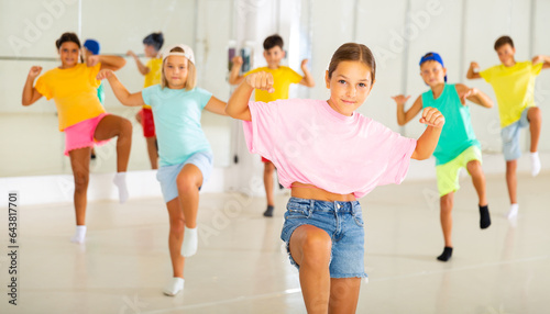 Active children dancing modern dances in a choreographic studio