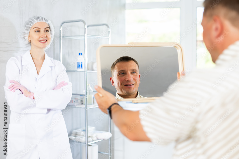 Obraz premium Young female doctor is satisfied with result of treatment and patient is satisfied with condition of facial skin, smoothed wrinkles