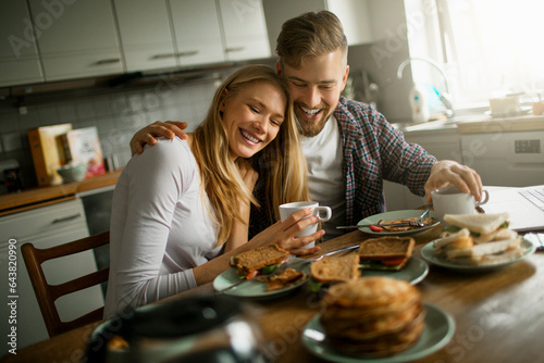 Young couple having breakfast and drinking coffee in the kitchen