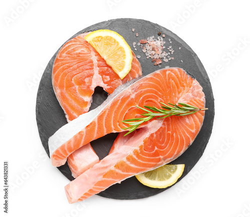 Board with raw salmon steaks and different spices on white background