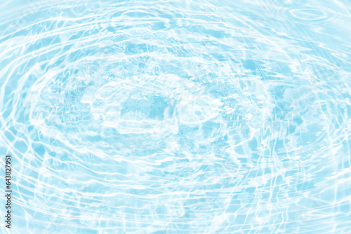 Blue water with ripples on the surface. Defocus blurred transparent blue colored clear calm water surface texture with splashes and bubbles. Water waves with shining pattern texture background.