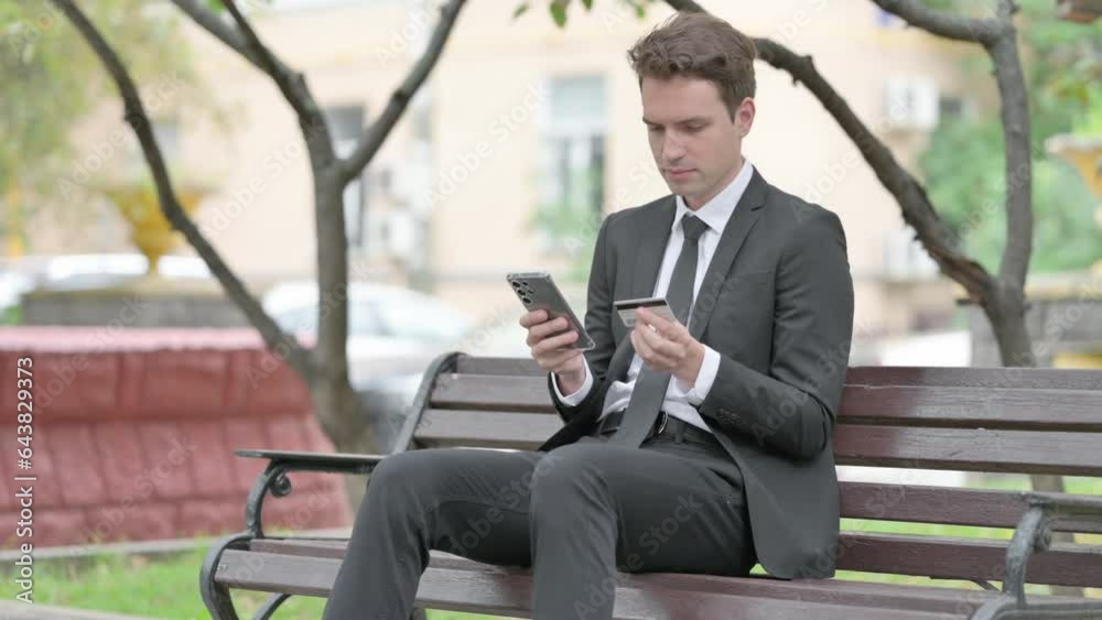 Businessman Shopping Online while Sitting on Bench Businessman Shopping Online while Sitting on Bench