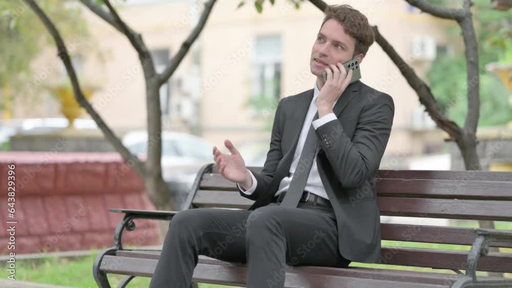 Businessman Talking on phone while Sitting on Bench Businessman Talking on phone while Sitting on Bench