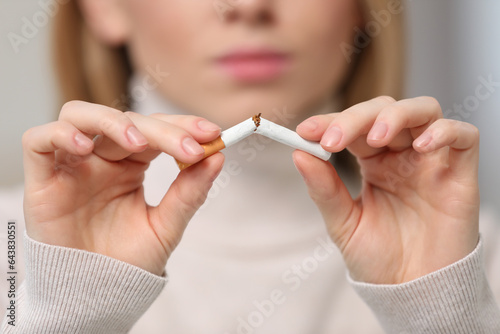 Stop smoking concept. Woman breaking cigarette  closeup