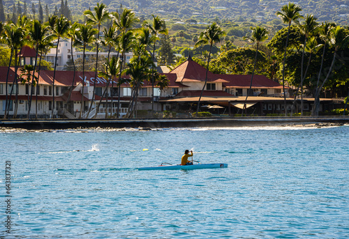 Outrigger Canoe Paddler and The Waterfront Of Kailua-Kona on Kailua Bay, Kailua-Kona, Hawaii Island, Hawaii, USA photo