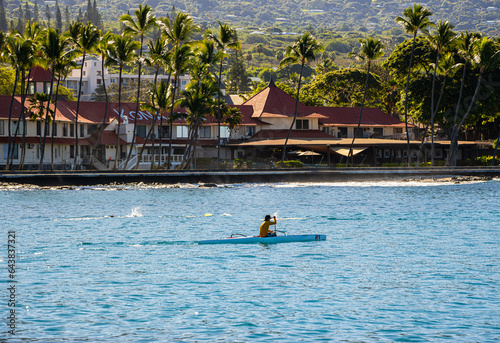 Outrigger Canoe Paddler and The Waterfront Of Kailua-Kona on Kailua Bay, Kailua-Kona, Hawaii Island, Hawaii, USA