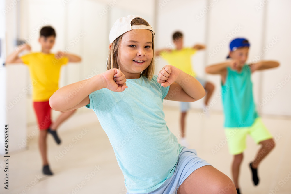 Girl and other kids dancing hip hop in dance studio