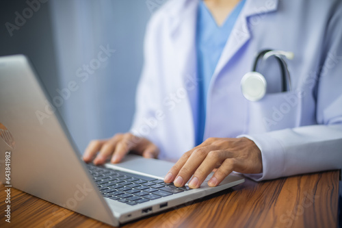 Doctor using laptop computer on desk office