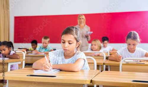 Young girl is sitting at the desk in the classroom elementary school