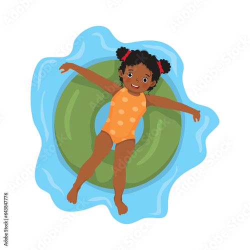 happy little African girl with swimsuit lying on inflatable rubber ring having fun floating in swimming pool on summer time