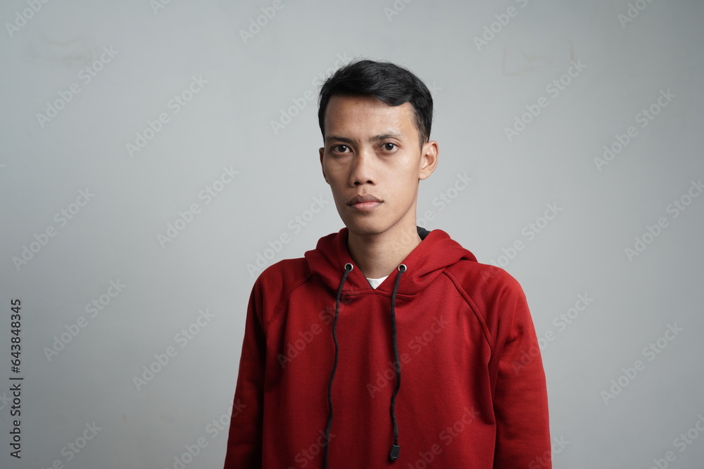 asian man wearing red hoodie standing straight, isolated white background. asian man wearing red hoodie standing straight, isolated white background.