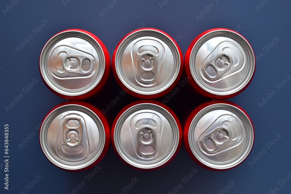 close up top of aluminium red cans soft drink put on blue texture background close up top of aluminium red cans soft drink put on blue texture background