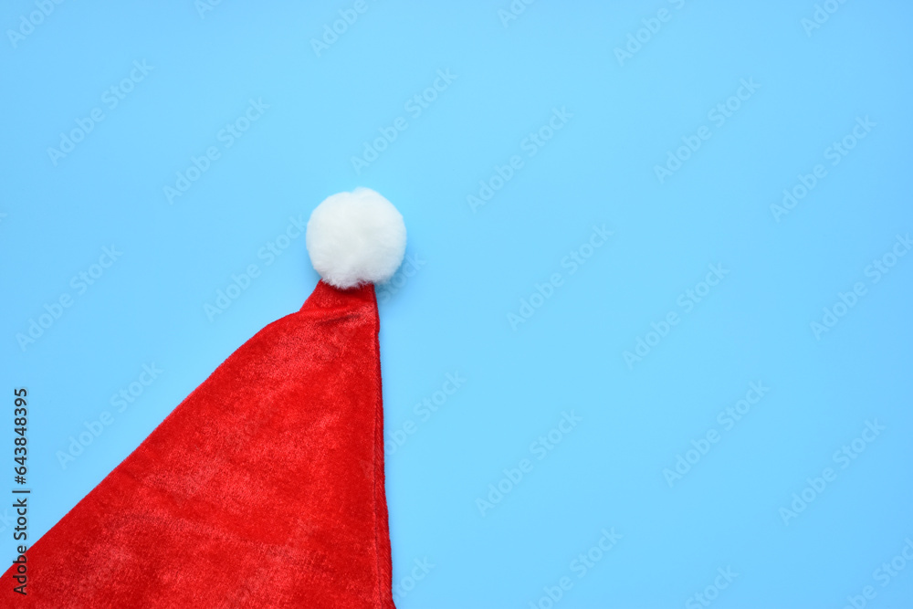 Santa claus red wool winter hat on blue background, christmas decoration Santa claus red wool winter hat on blue background, christmas decoration
