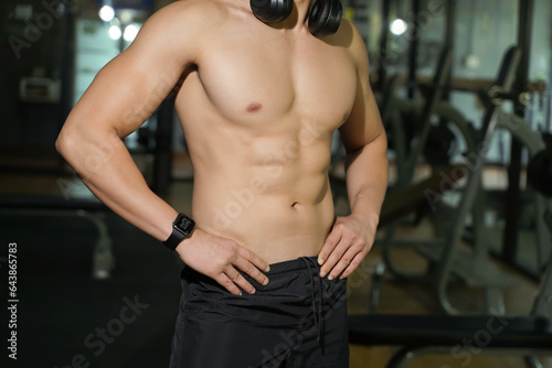 Closeup and crop perfect body of guy relaxing after workout at fitness center.