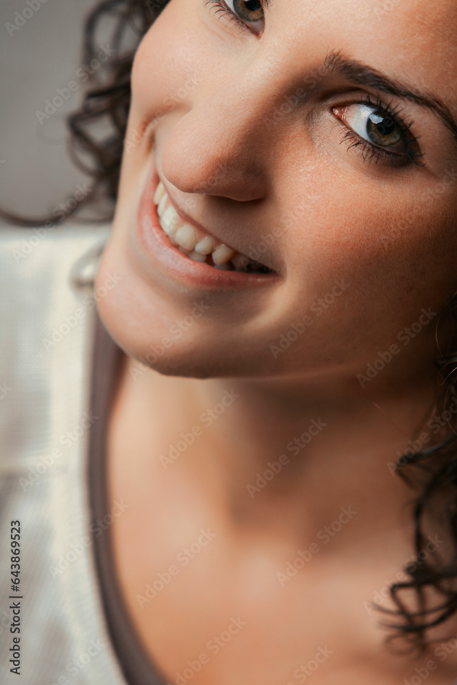 Fototapeta premium Curly woman smiles, future bright, eyes gleaming