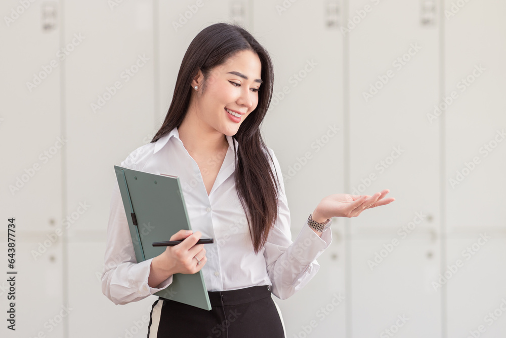 Image of young asian woman, company worker smiling and holding documents of contracts with signature and seal, standing over white background Image of young asian woman, company worker smiling and holding documents of contracts with signature and seal, standing over white background