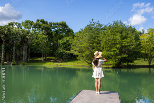 Woman walking along the wooden walkway over the lake