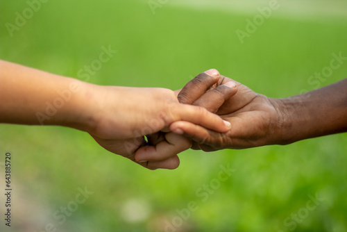 A white man's hand exchanging love with a black man's hands © Rokonuzzamnan