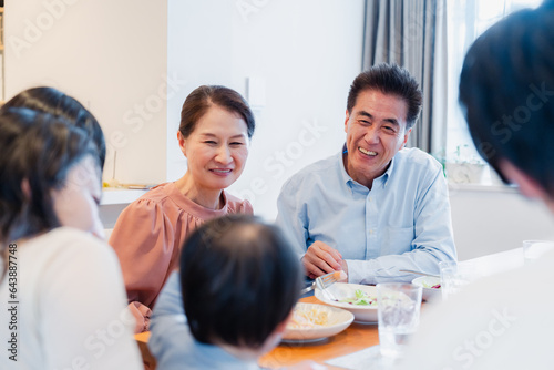 孫たちと一緒に楽しくごはんを食べる高齢の夫婦