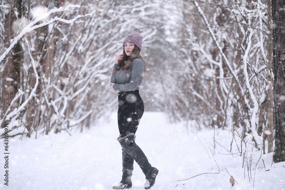 Girl in a winter park in snowfall Girl in a winter park in snowfall
