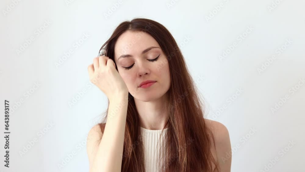 A beautiful woman gives a facial massage with a silver facial massager to relieve facial swelling A beautiful woman gives a facial massage with a silver facial massager to relieve facial swelling