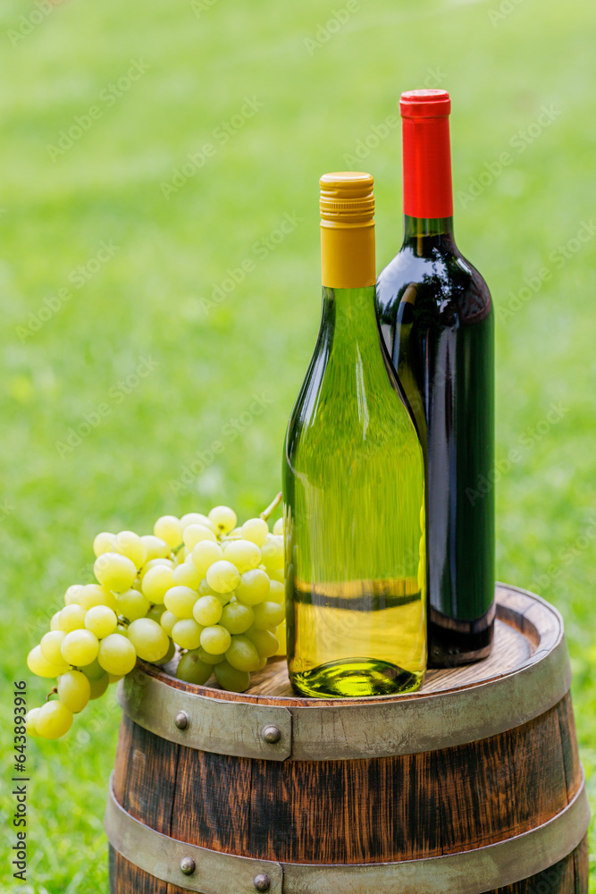 Wine bottles and grape on barrel
