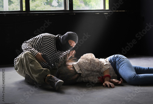 scene of psychopathic thief looks filthy evil has a gun is about to harass a young woman by sniffing victim hair that lying on floor,concept of woman victim,violence,hostage,crime,sexual harassment photo