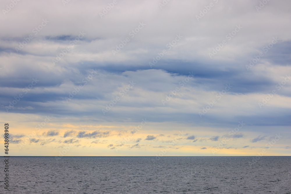 Clouds and dawn light over vast calm open ocean to horizon