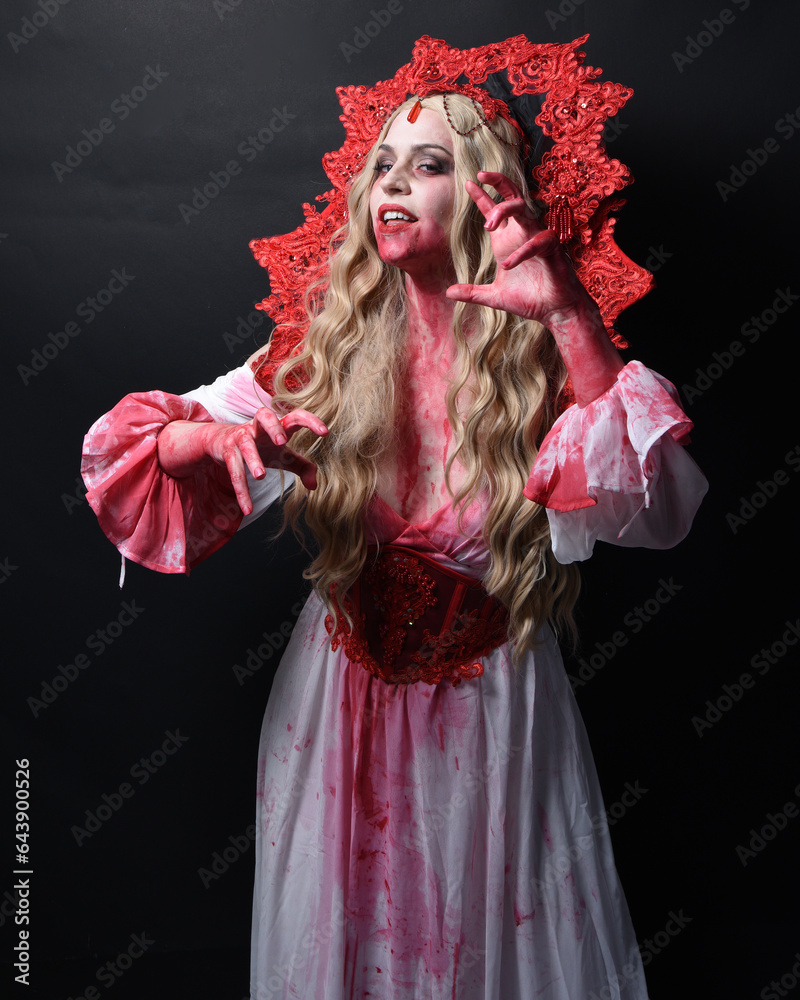 Close up portrait of scary vampire zombie queen, wearing elegant halloween fantasy costume . Isolated on dark studio background with gestural hands reaching out towards camera. Close up portrait of scary vampire zombie queen, wearing elegant halloween fantasy costume . Isolated on dark studio background with gestural hands reaching out towards camera.