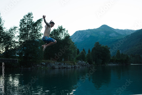 man jumping into a Norwegian fjord in summer