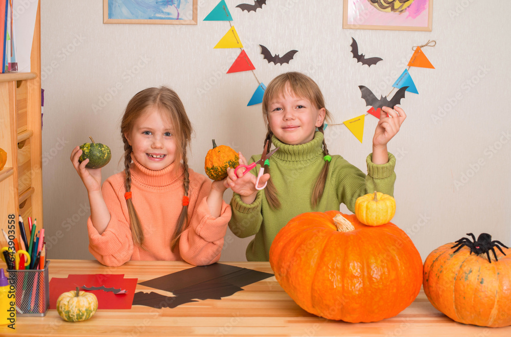 Fototapeta premium Smiling girls making decorations for Halloween.