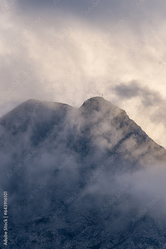 Mountain peak partially covered with clouds at sunset