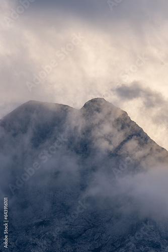 Mountain peak partially covered with clouds at sunset
