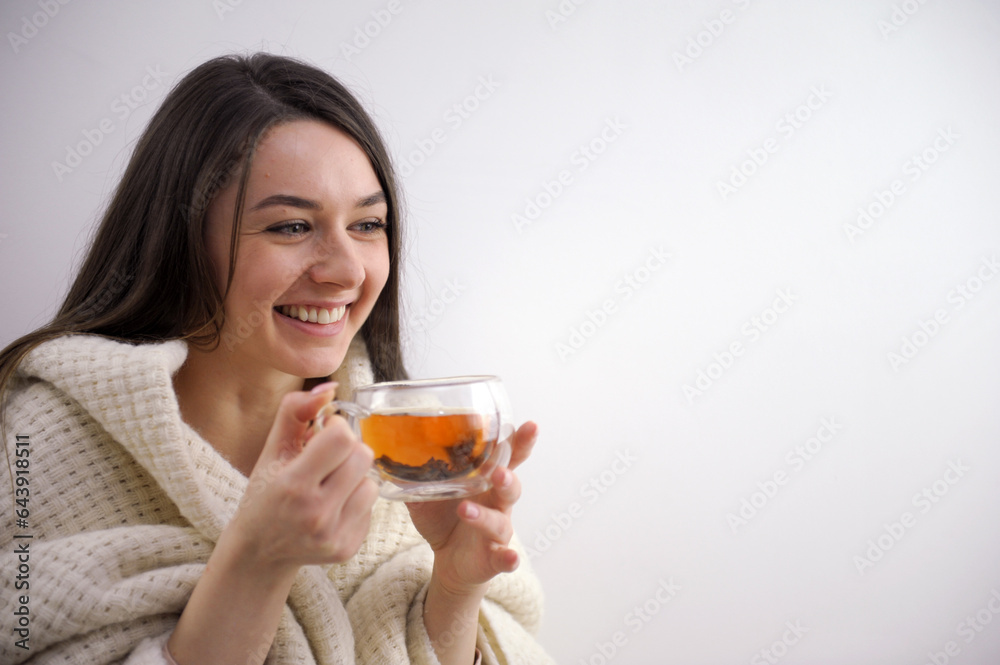 Drink Tea to relax cozy photo with blurry background. Women's hands hold a mug of hot tea in the morning. A young woman relaxing a cup of tea at hand. Good Morning Tea or Happy Day Message Concept.